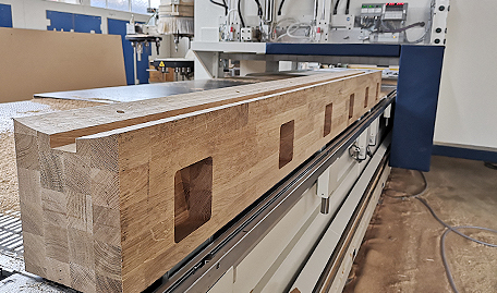 Maschinenbauteil aus Holz liegt auf CNC-Maschine
